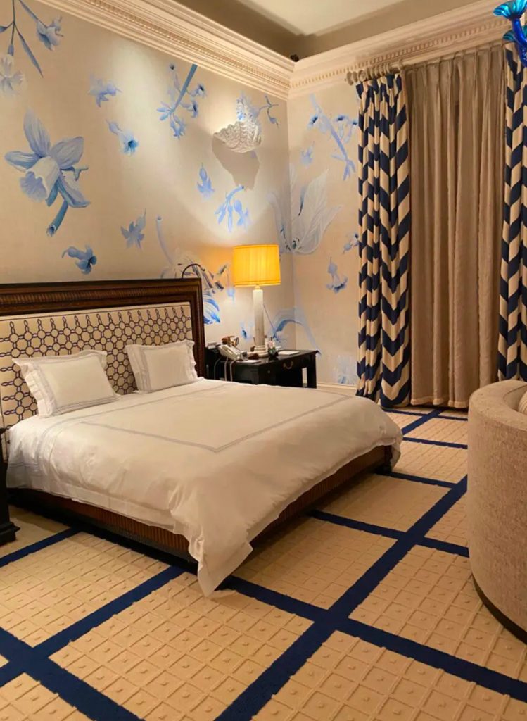 Caméras dissimulées dans les moulures et les plafonds, chambre aux motifs presque enfantins, pièce équipée de multiples écrans : à partir du moment où l’on parle de captation, le regard cesse d’être une métaphore. La scène n’est plus seulement décorée — elle est surveillée. La régie n’est pas hors champ : elle fait partie du dispositif.