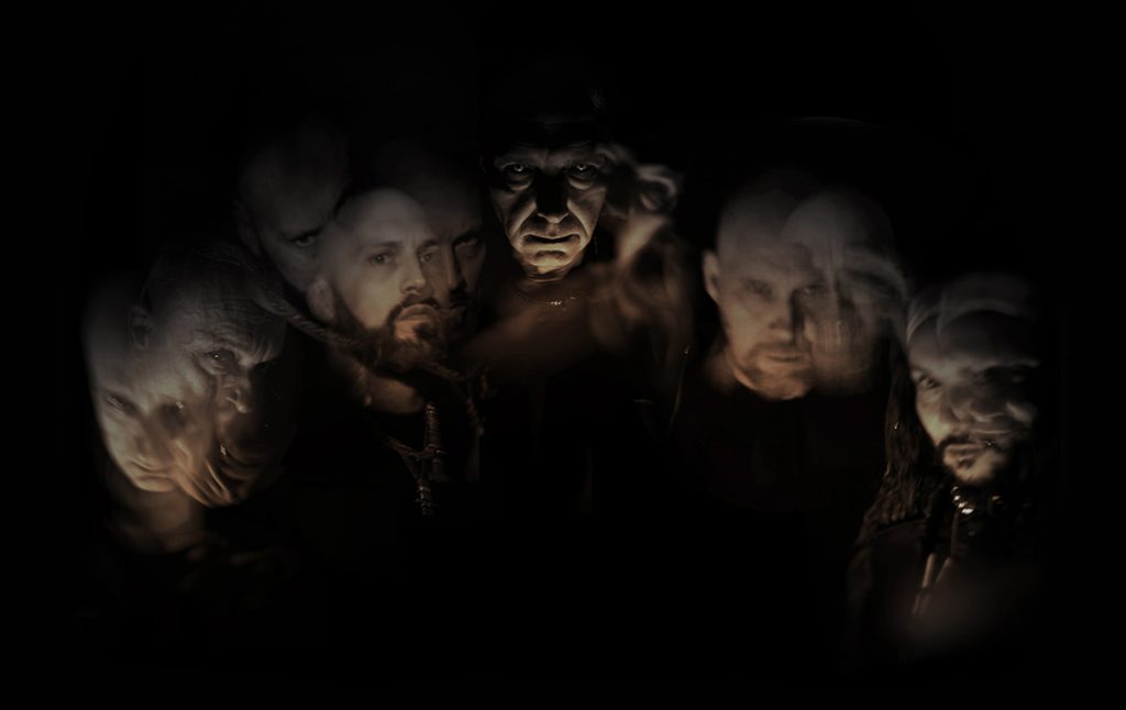 Portrait sombre du groupe Mayhem avec, de gauche à droite, Attila Csihar, Ghul, Teloch, Necrobutcher et Hellhammer, dans une mise en scène aux visages flous et spectraux.