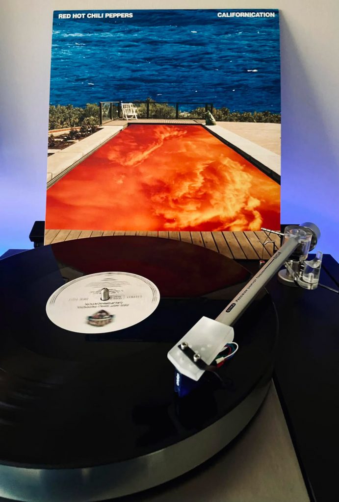 Vinyle de l’album Californication des Red Hot Chili Peppers posé sur une platine, avec sa pochette physique.